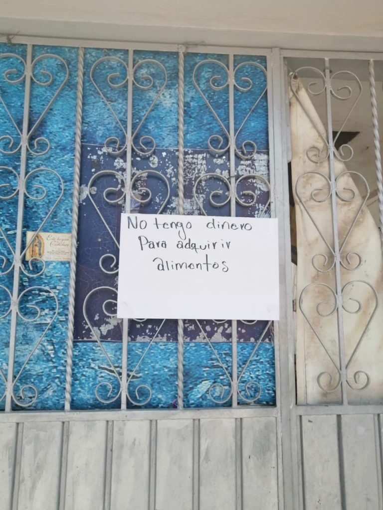 Vecinos de Casa Blanca colocan cartulinas solicitando apoyo de despensas.