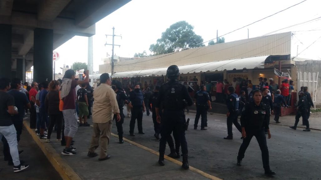Video desde Puebla: Graban a policía municipal cuando golpeó a mujer arriba de la patrulla después de la trifulca en el mercado Amalucan