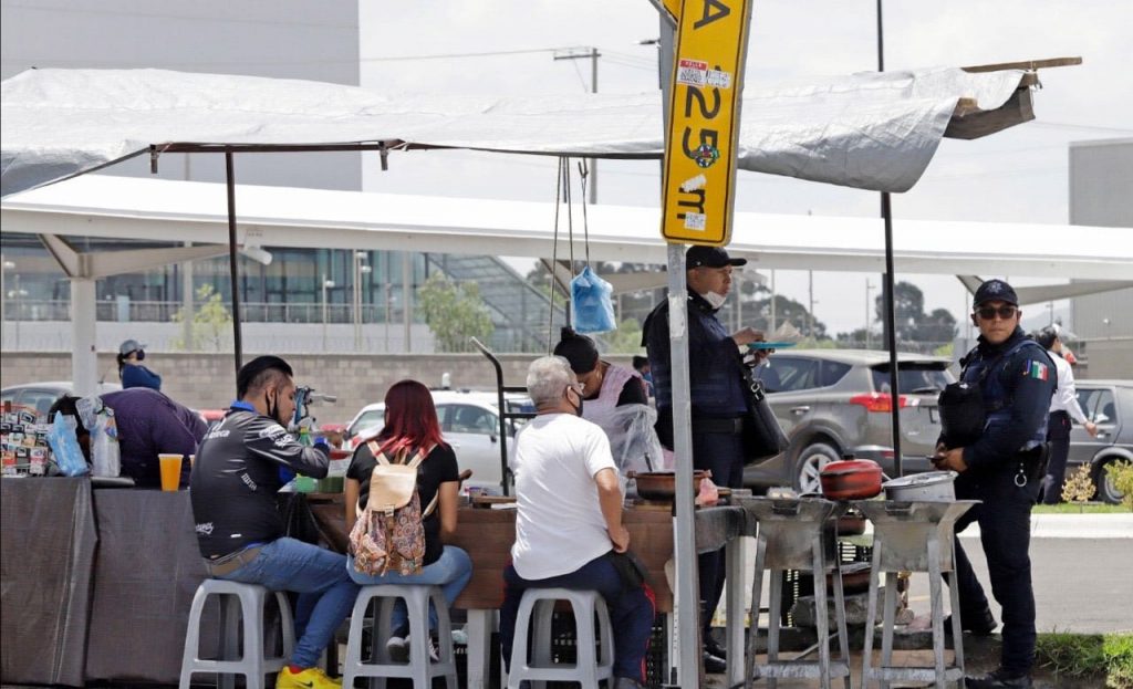 Policías municipales comen en un puesto ambulante en Calzada Ignacio Zaragoza