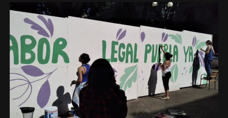 Video desde Puebla: Feministas exigen despenalización del aborto y utilizan los muros de madera colocados en el zócalo para obras