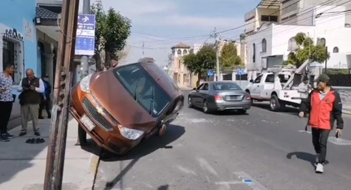 Video desde Puebla: Fuerte choque provoca que uno de los autos quede recargado del poste de luz