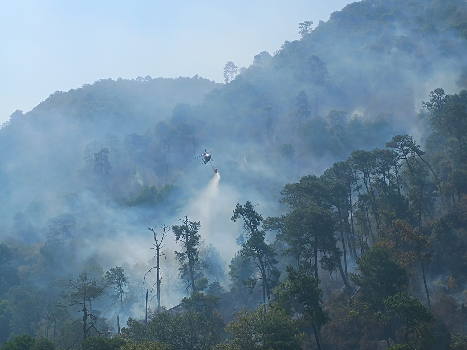 Inician descargas de agua con helicóptero sobre incendio forestal de Juan Galindo: Sergio Salomón